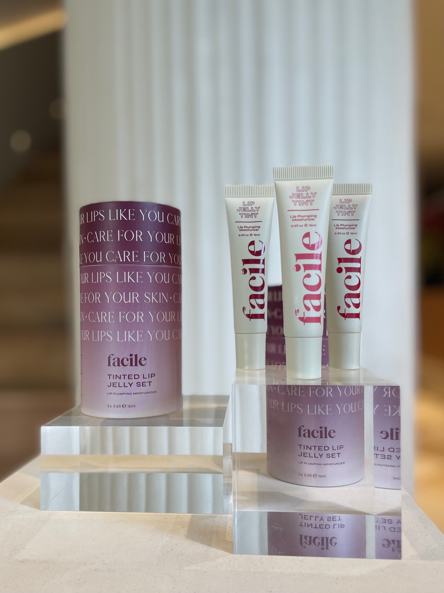 Close-up of Facile Lip Jelly tubes and a Tinted Lip Jelly Set on acrylic risers