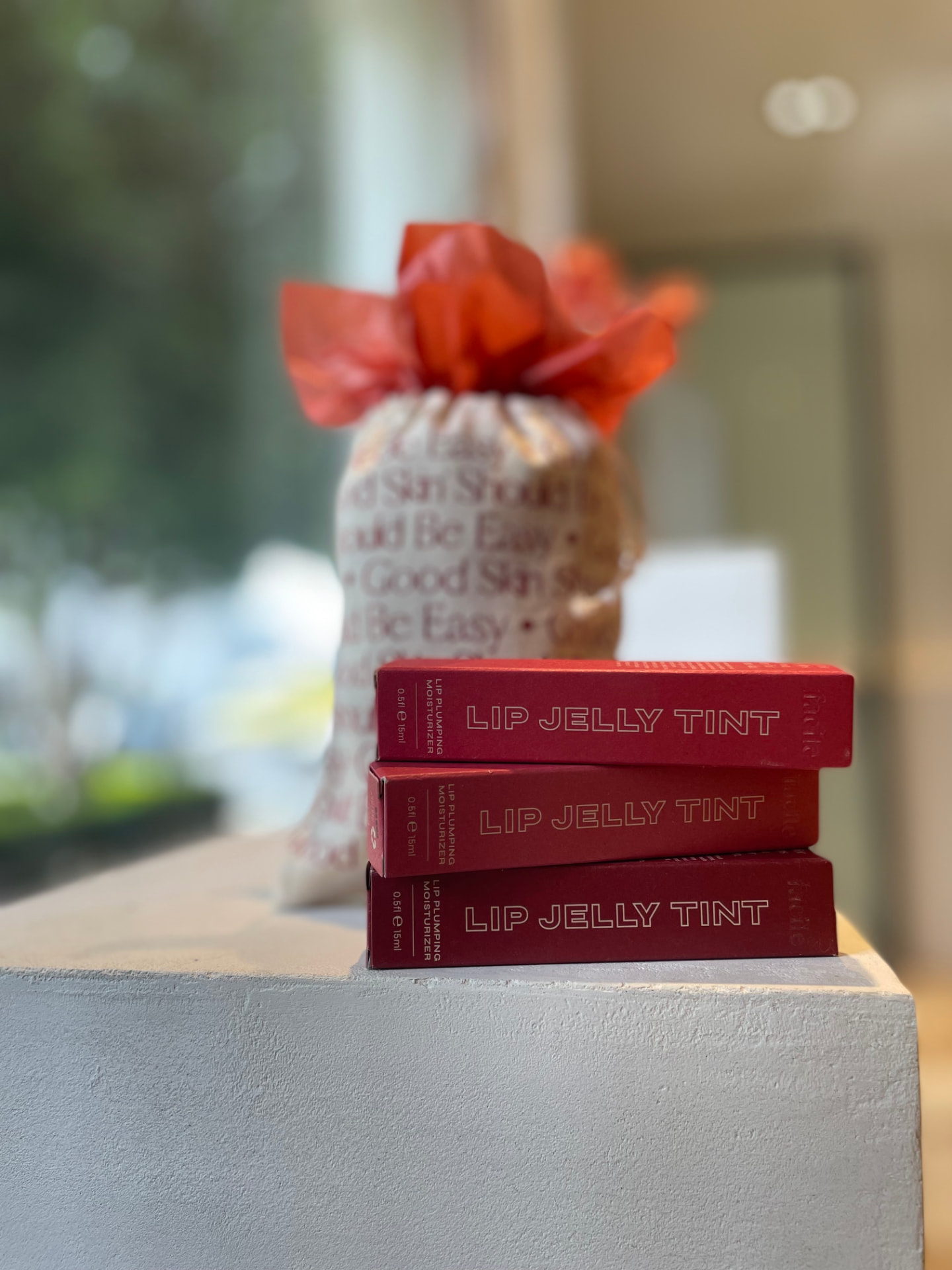 Facile Lip Jelly Tint boxes stacked next to a wrapped gift bag