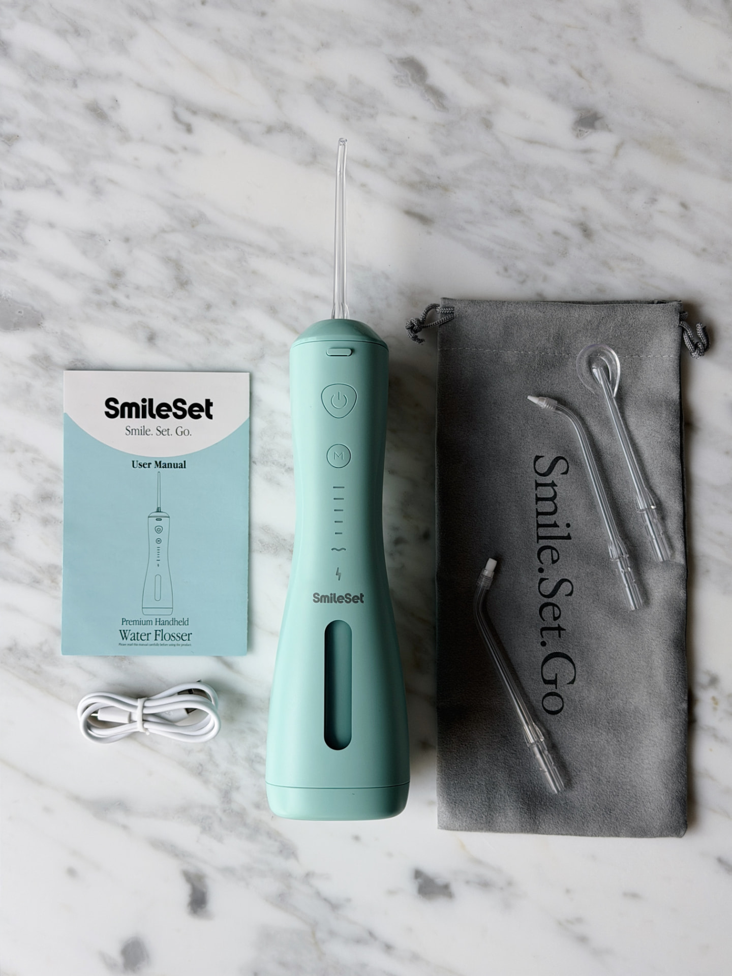 SmileSet water flosser flatlay with manual and accessories
