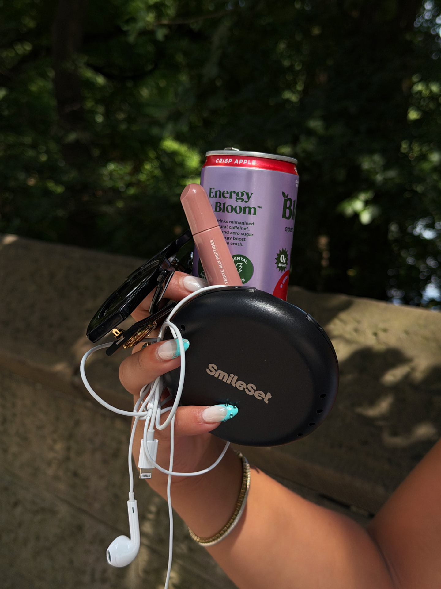 SmileSet aligner case held outdoors with sunglasses and a canned drink