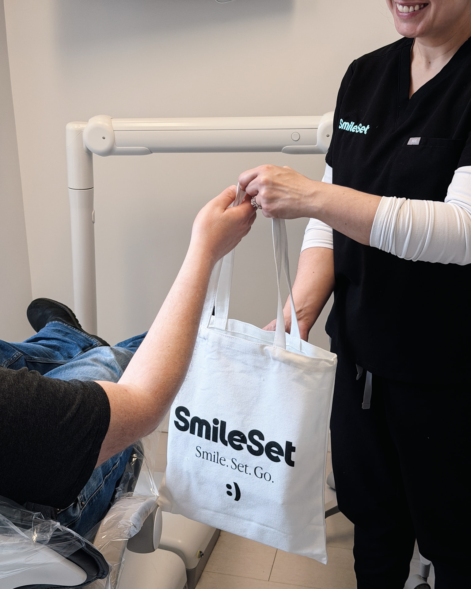 Patient receiving a SmileSet branded tote bag after their appointment