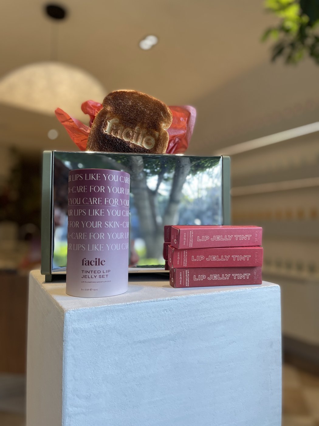 Facile toast and Lip Jelly Tint display on a white plinth inside the Facile flagship